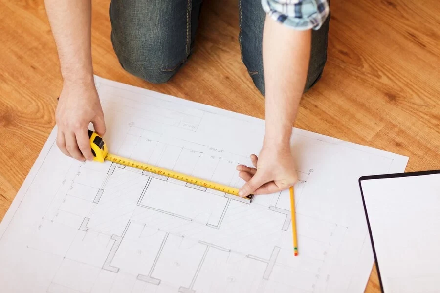 Personne prenant des mesures sur un plan d’aménagement