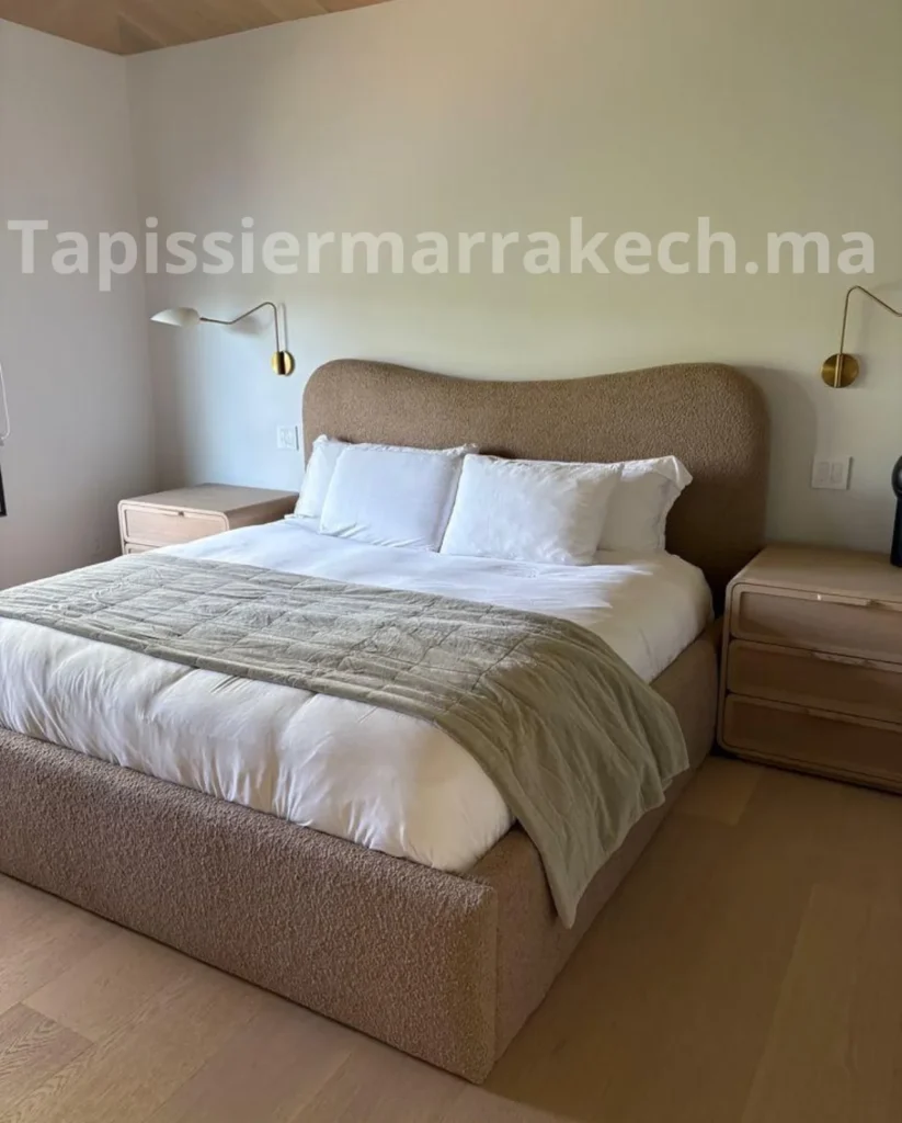 Lit beige et tête de lit arrondie dans une chambre aux tons verts