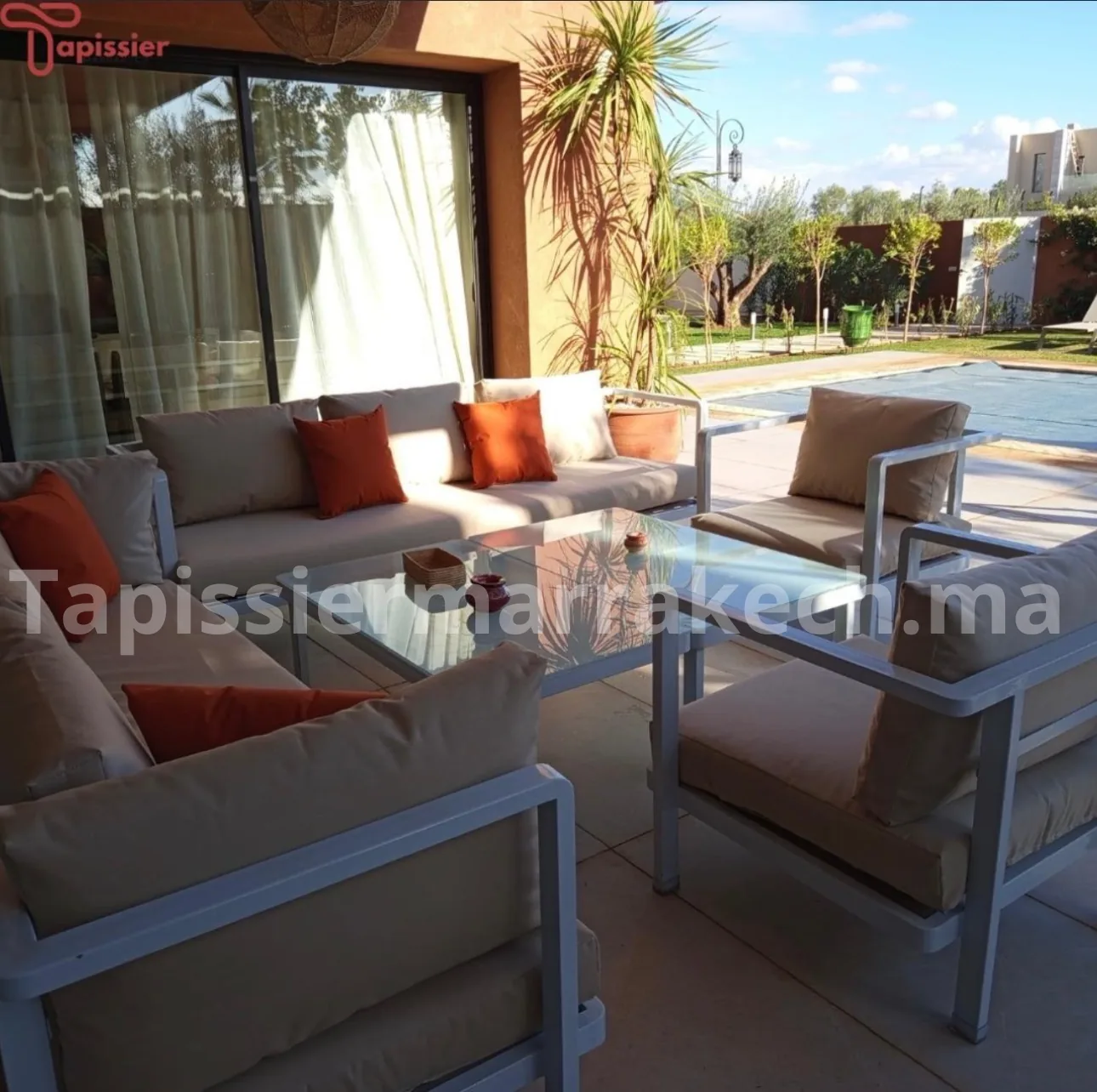 Salon extérieur blanc avec coussins orange sur une terrasse